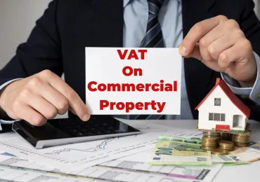 Accountant holding card reading VAT on Commercial Property
